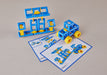 Blue and yellow plastic building blocks arranged to form a small vehicle and a separate frame structure, with two printed instruction sheets placed in front on a light beige surface.