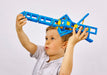 Child holding a blue and yellow toy structure above their head against a white background